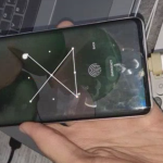 Photo of a smartphone with the ATTiny85 inserted into it, with a screen unlock pattern being drawn on the screen
